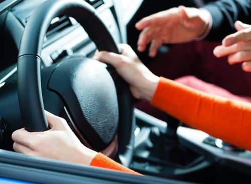 Driving instructor teaching his student how to drive