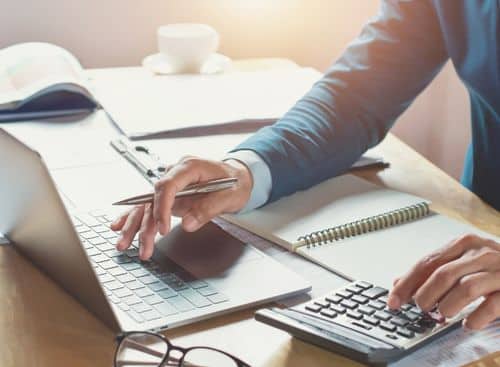 Tax advisor using a laptop and calculator